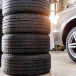 Car wheel repair with two auto lift back view. Seasonal winter tyre change at workshop. Vehicle tire