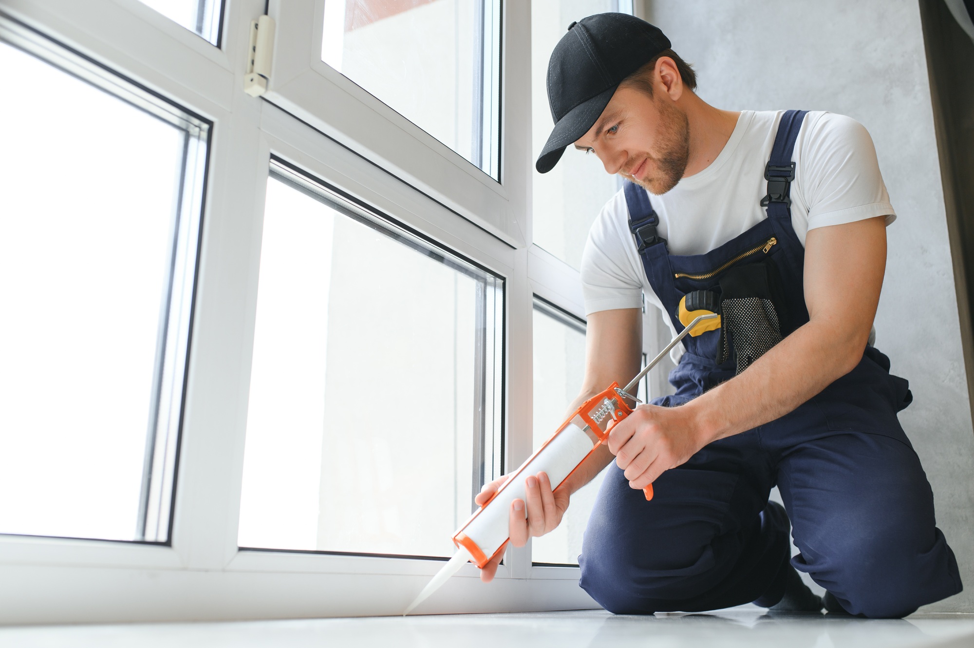 Construction worker installing window in house